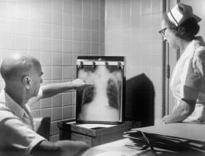 patient and doctor in a black and white photo with a chest x-ray