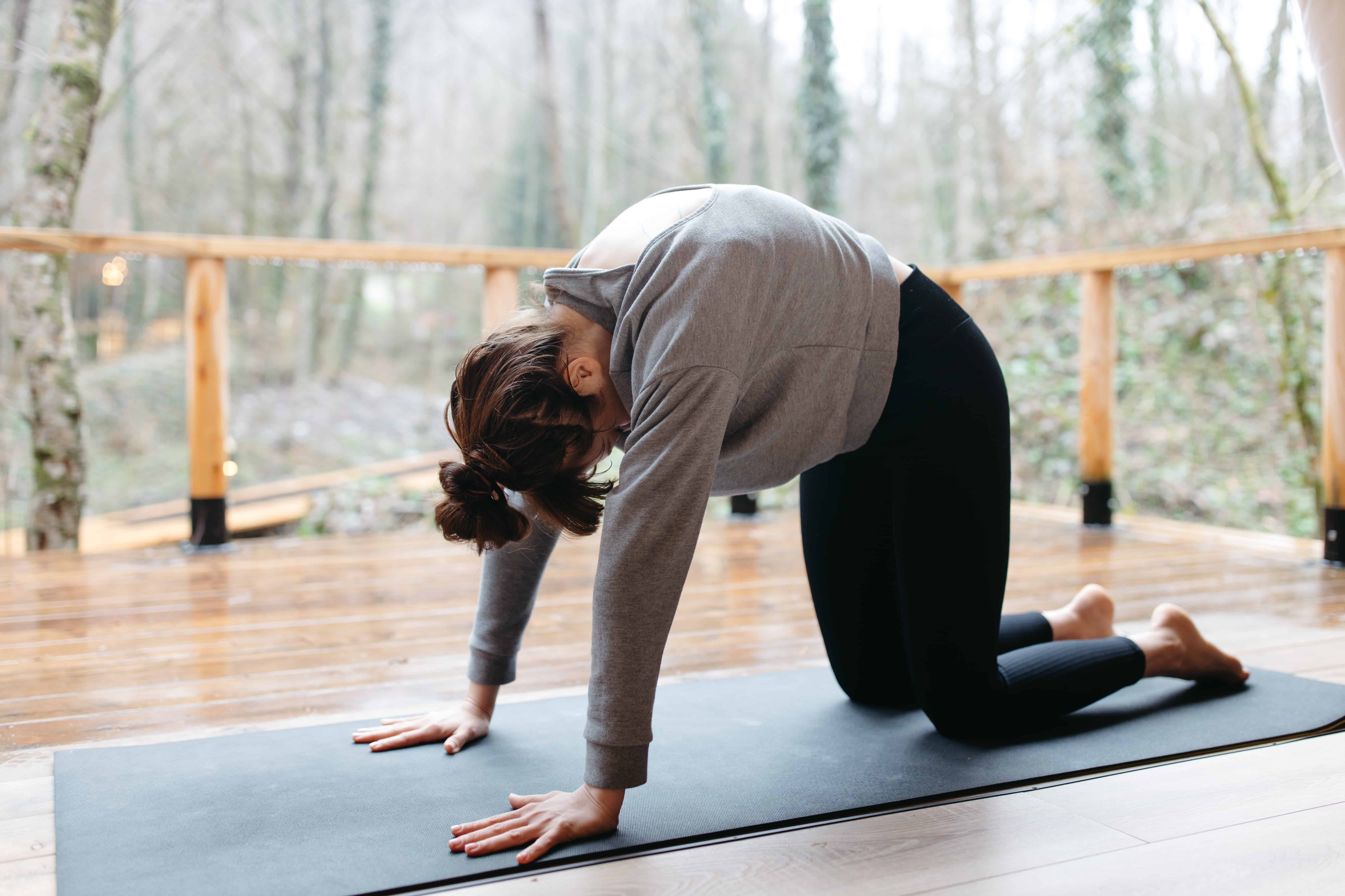 A woman performing cat-camel stretching pose