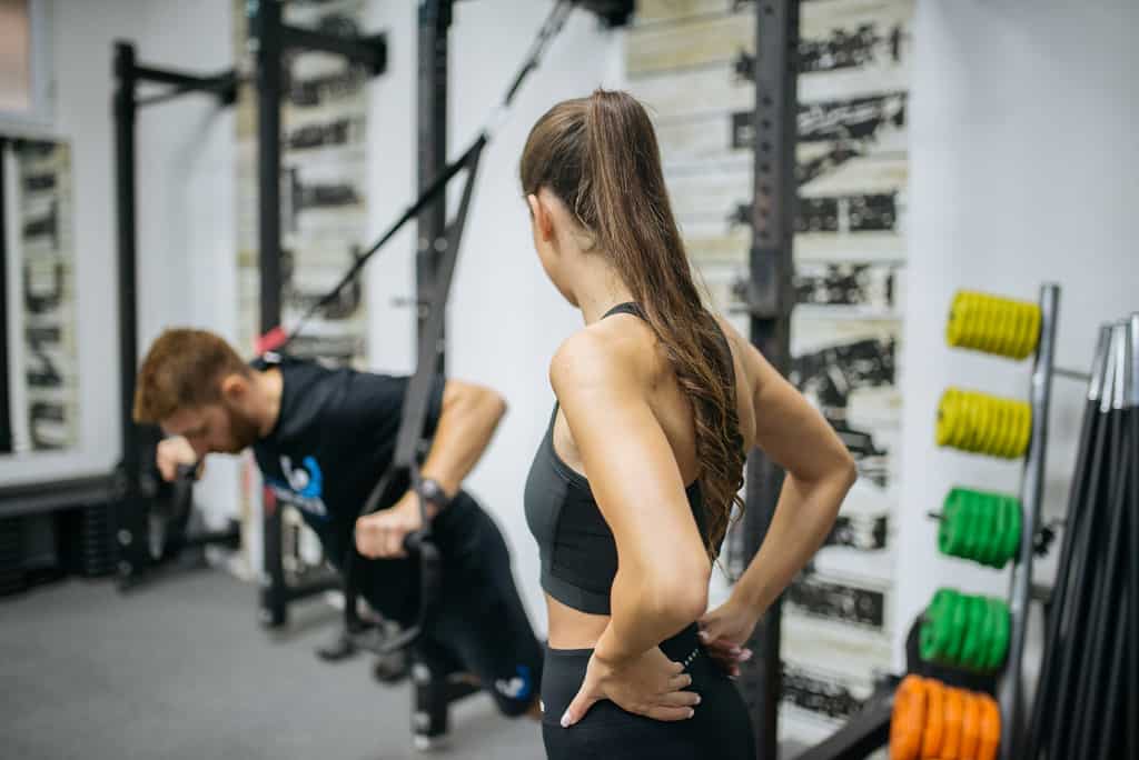 A woman watching her coach doing the crossover exercise