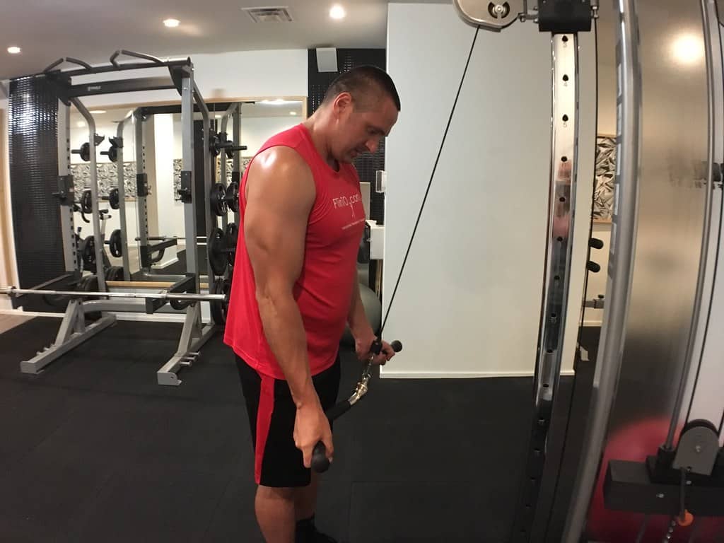 A man doing the cable crossover workout at the gym