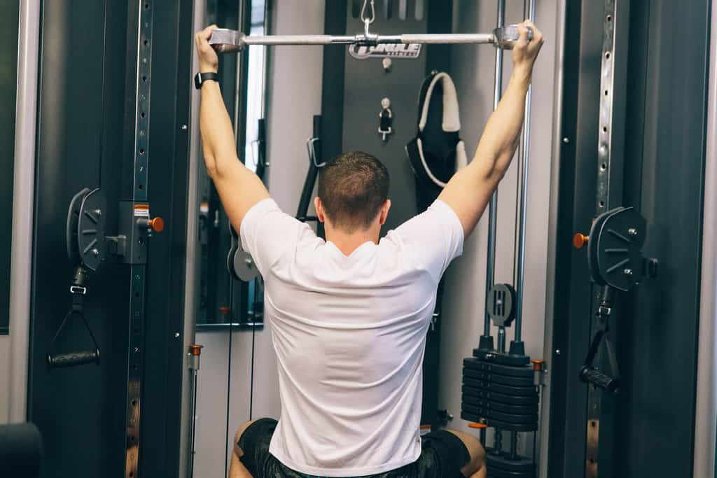 A man performing back muscle exercise at the gym