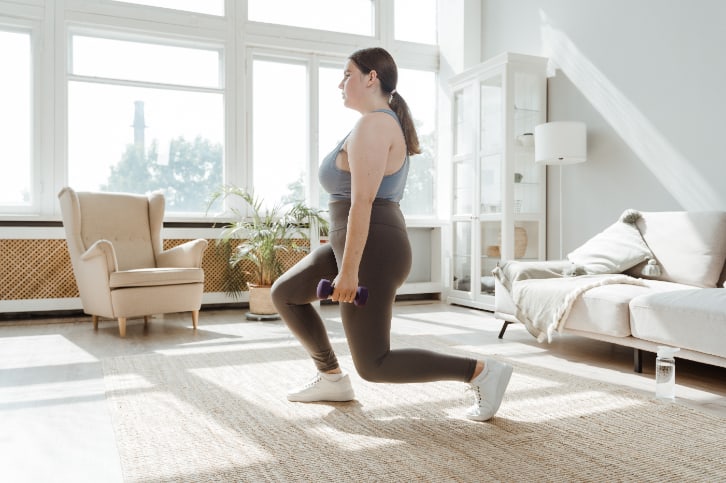 A woman doing lunges at home
