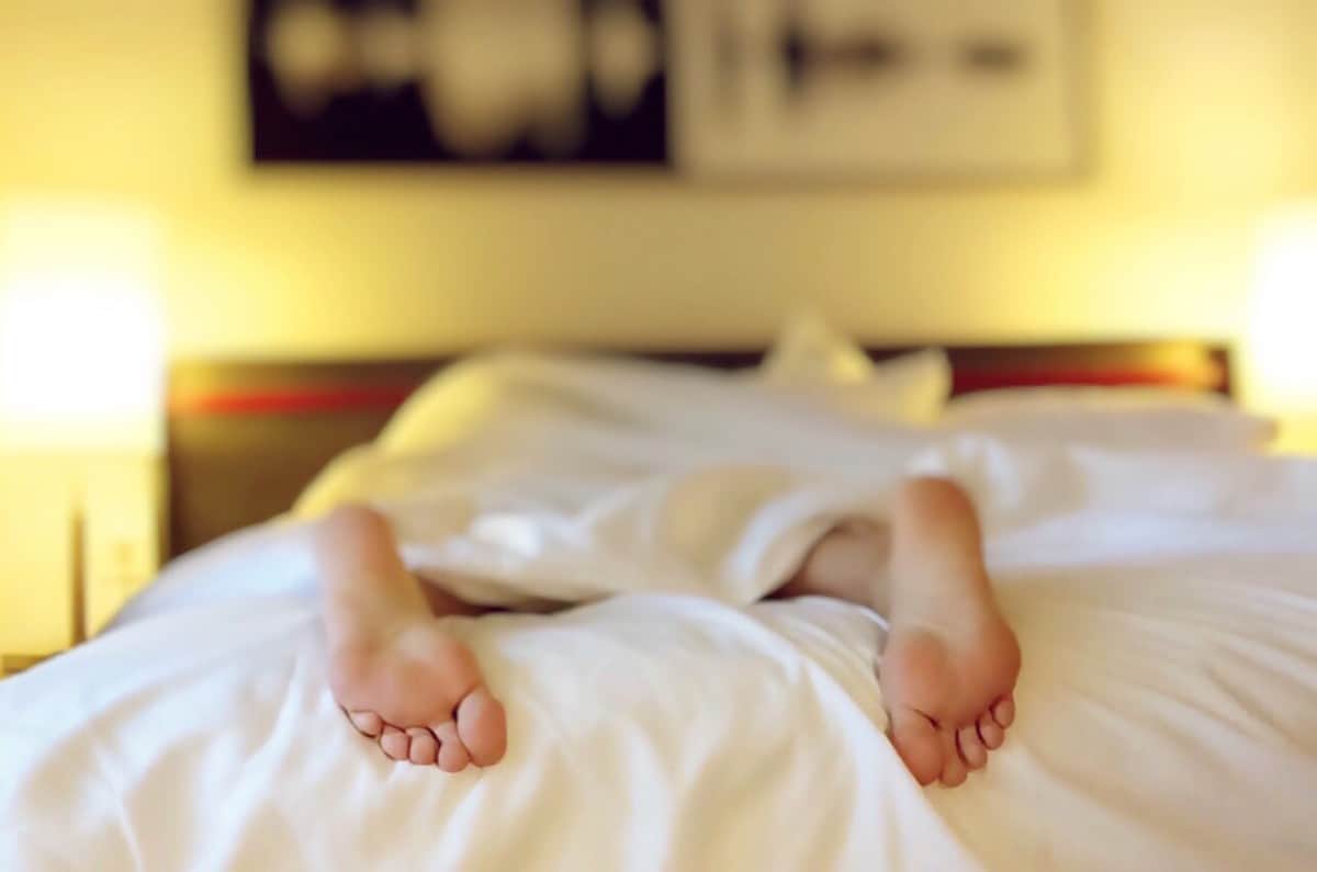 A close up photo of a person's feet on the bed
