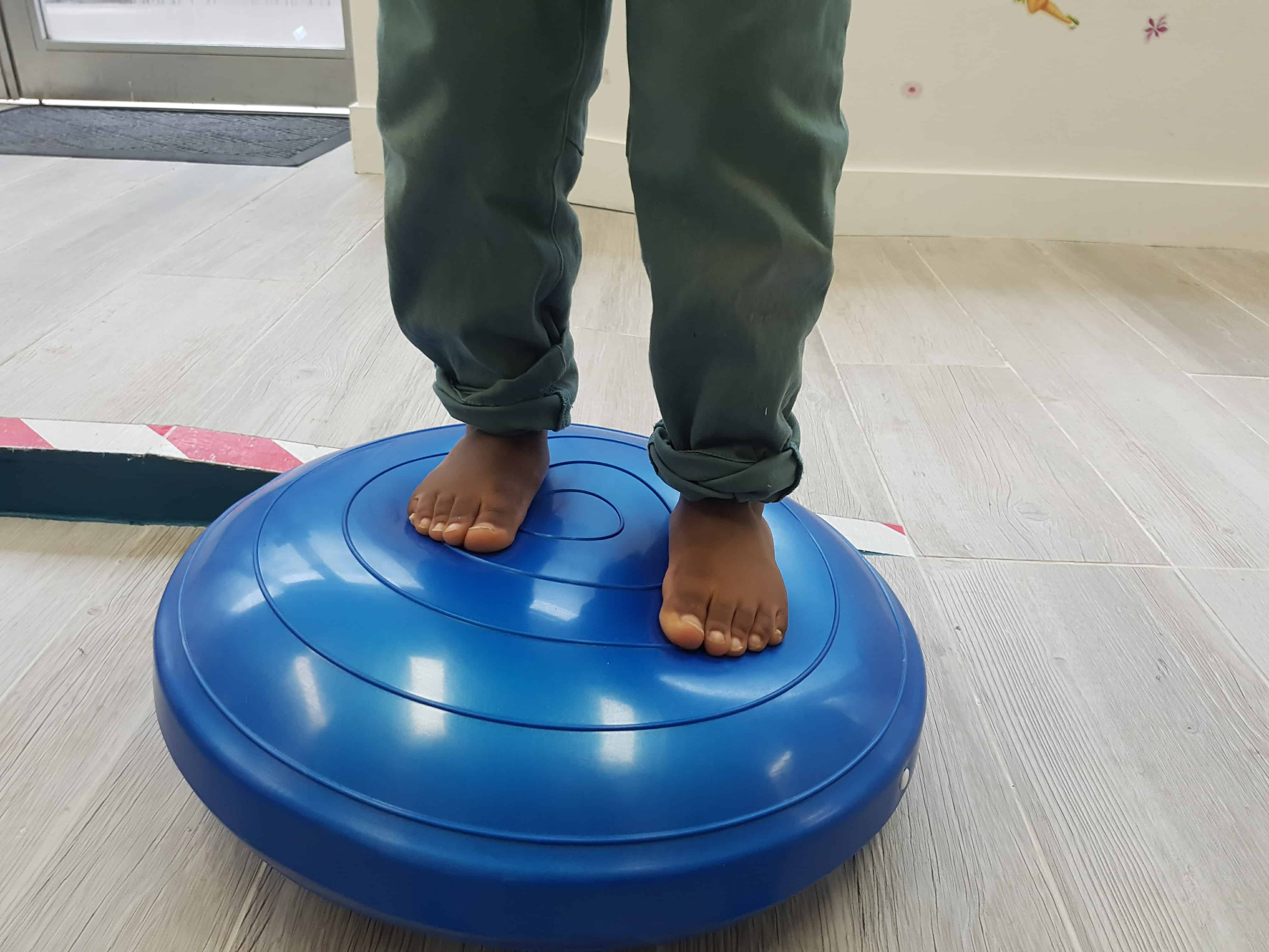A person stepping on a wobble board, trying to balance