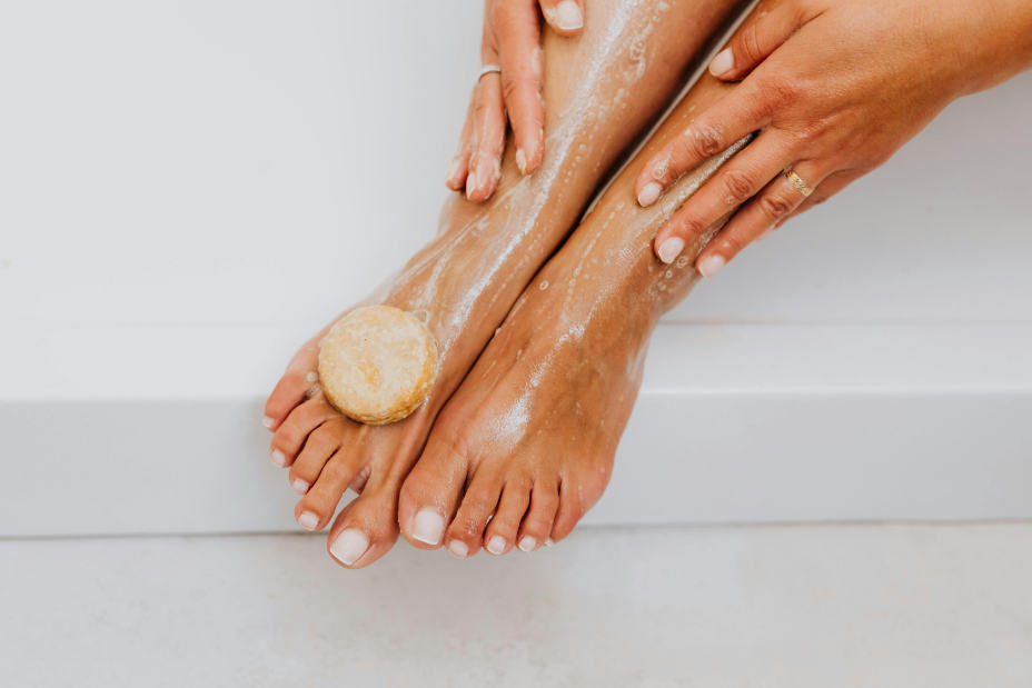 Close-up of woman washing feet with organic soap.
