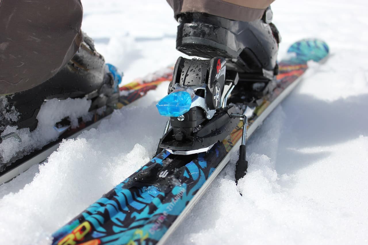 Ski boot with attached binding on a ski.
