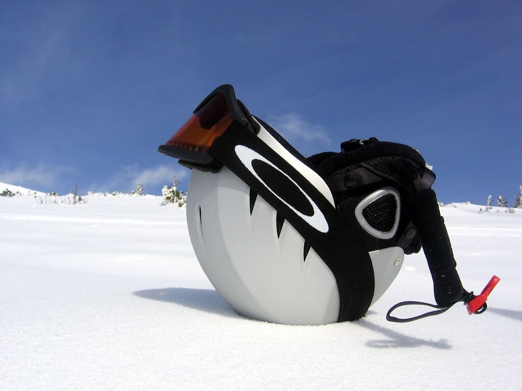 White ski helmet placed on a snowy surface.