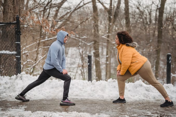 A couple warming up during an outdoor training in winter time.