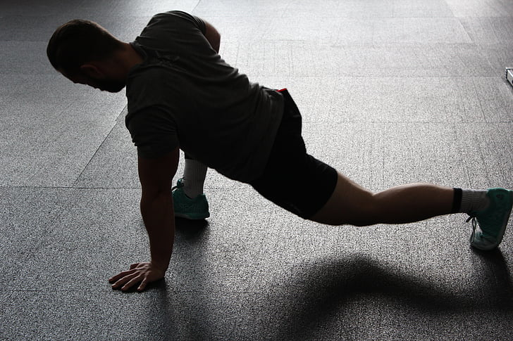 Man performing dynamic stretching at the gym.
