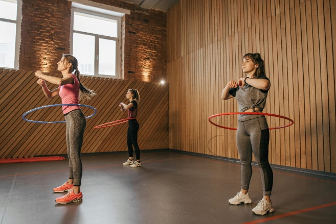 Women exercising with hula hoops.